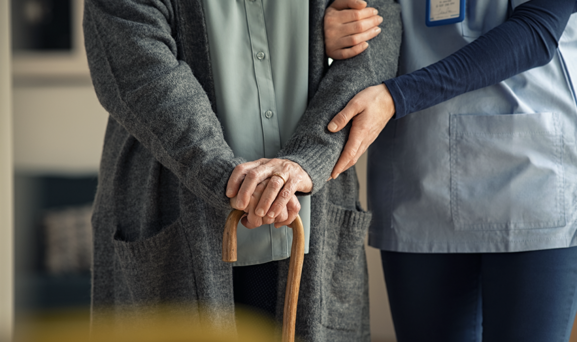 Nurse assisting elderly grandparent with walking during in-home care visit through House Call The App